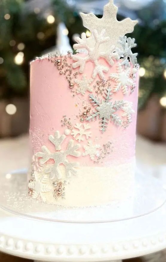 a pink and white wedding cake decorated with edible beads, white and silver snowflakes all over is a chic and lovely idea