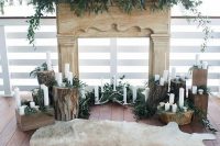 a rustic wedding ceremony backdrop of a faux mantel, greenery, antlers, tree stumps with candles and antlers and a fur rug