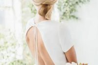 a sleek minimalist twisted low updo with a sleek top is ideal for a minimalist or modern bride