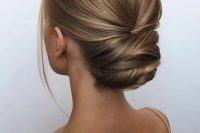 a sophisticated modern twisted updo with a sleek yet deimsnional top and a bit of locks to frame the face is a great idea for a formal wedding