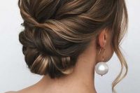 a twisted low bun with a bump on top and some face-framing waves is a cool idea for a bride