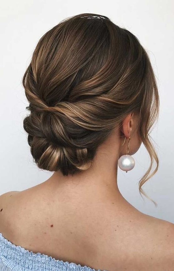 A twisted low bun with a bump on top and some face framing waves is a cool idea for a bride