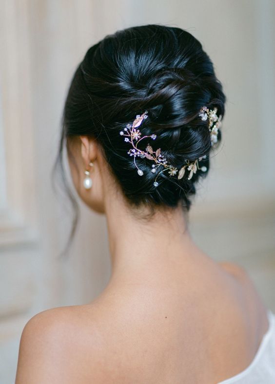 A twisted updo with a hair vine and some face framing locks is a cool idea for a bride with medium length hair