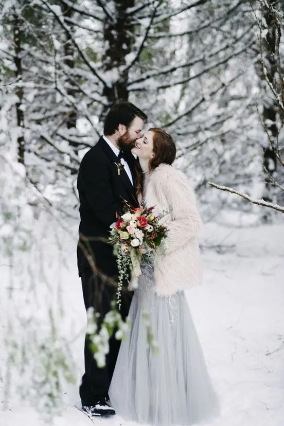 a white fuzzy fur coat over a grey embellished wedding dress is a trendy and chic idea to keep you warm