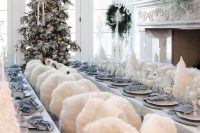 a winter wonderland styled in white and grey, with  white Christmas trees, faux fur and paper snowflakes over the space