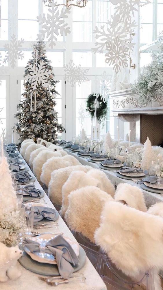 a winter wonderland styled in white and grey, with  white Christmas trees, faux fur and paper snowflakes over the space
