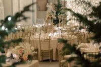 a winter wonderland wedding reception space with a light canopy over it, Christmas trees and candles is amazing