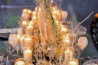 a winter wonderland wedding tablescape with frozen branches and baby’s breath, floating candles is enchanting