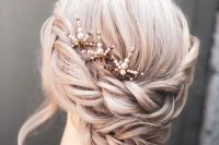 a woven braided low updo with a bump on top and face-framing locks plus pearl hair pieces is cool