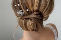 a wrapped low bun with a bump on top and pearl and rhinestone hairpins plus a star hairpin is a lovely idea for any bride