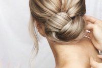 an elegant low chignon bun with a bump on top and face-framing hair is a lovely idea for a modern bride