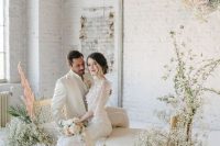 an ethereal wedding lounge with baby’s breath overhead installations and matching bench decor is amazing