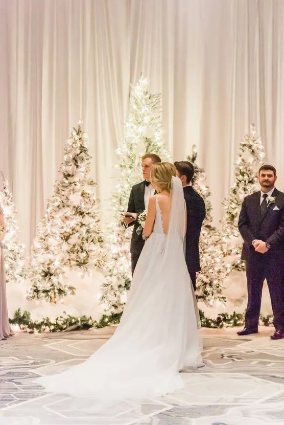 flocked Christmas tree with a lot of lights are a perfect winter or Christmas wedding backdrop