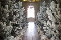 flocked Christmas trees, snowy firewood and artificial snow turn this Christmas wedding ceremony space into a real snowy forest