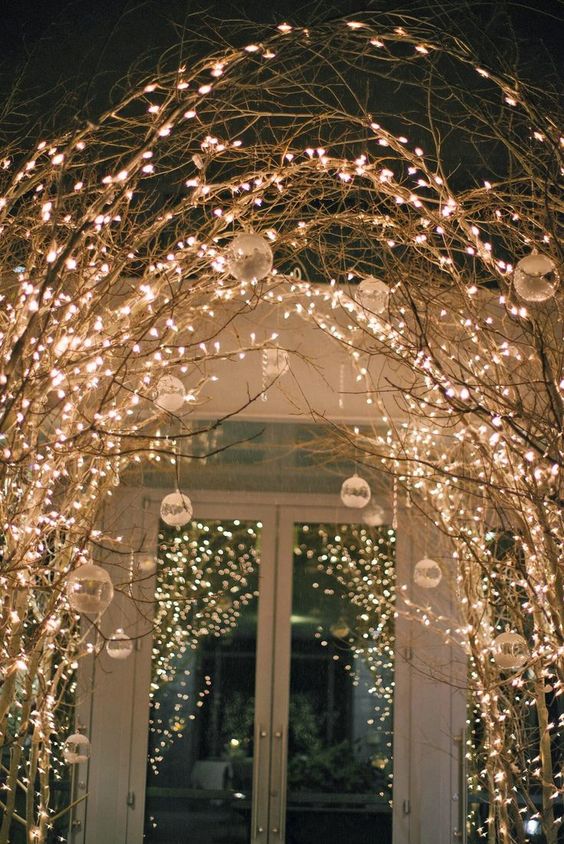 interwoven branches and twigs with lights and frozen ornaments can substitute a winter wonderland wedding arch