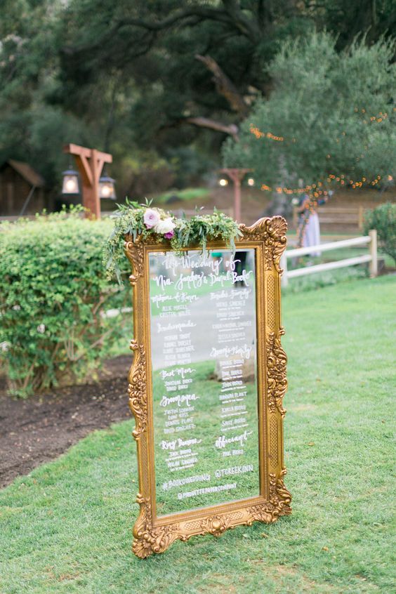 framed antique mirror sign with greenery and flowers