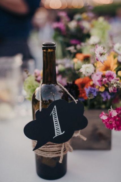 wine bottles with chalkboard table numbers tied with twine