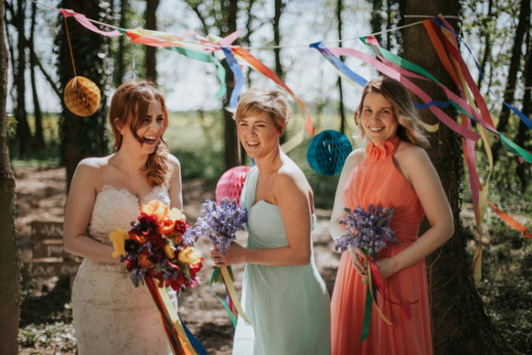 The bride was wearing a sweetheart wedding gown, and the bridesmaids were dressed in aqua and orange that fit the color scheme
