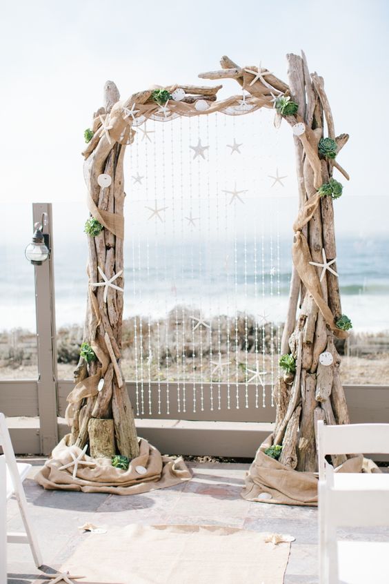 large driftwood wedding arch decorated with shells and star fish