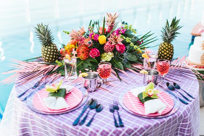 The sweetheart table was decorated in super bold tropical colors, with tropical flowers and palm leaves and pineapples for decor