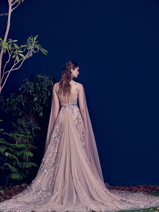 The dress has an illusion back, a train and cape-styled sleeves