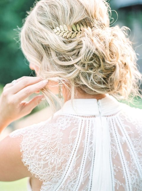 messy blonde wavy updo with a gold hairpiece
