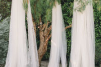 09 The ceremony site was decorating in a flowing and romantic way, with tulle draperies and bright florals