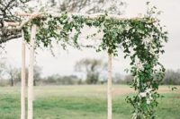 11 earthy and rustic chuppah with draped fabric ceiling and dark foliage