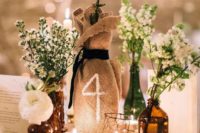 13 centerpiece with small bottles with flowers and tealights, table number on the burlap sack