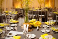 16 dark grey tablecloth with yellow napkins and a floral centerpiece