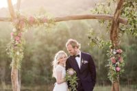 16 rough wood wedding arch decorated with flowers and greenery
