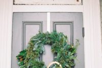 17 winter wedding wreath with rope on the bride’s home door