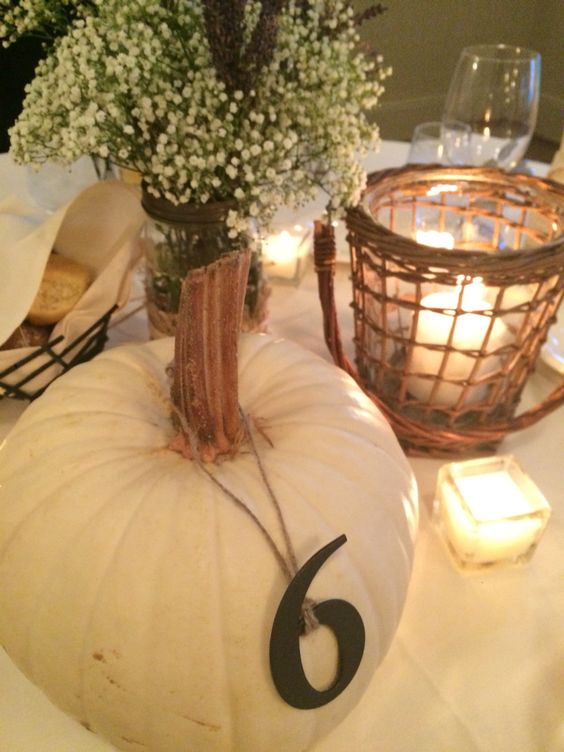 table number hanging on a white pumpkin for fall nuptials