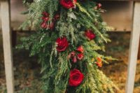 19 lush evergreen table runner with red roses for a rustic winter wedding