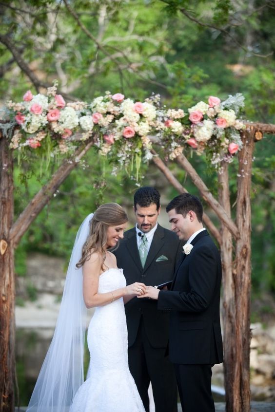 rustic wooden arch topped with lush florals