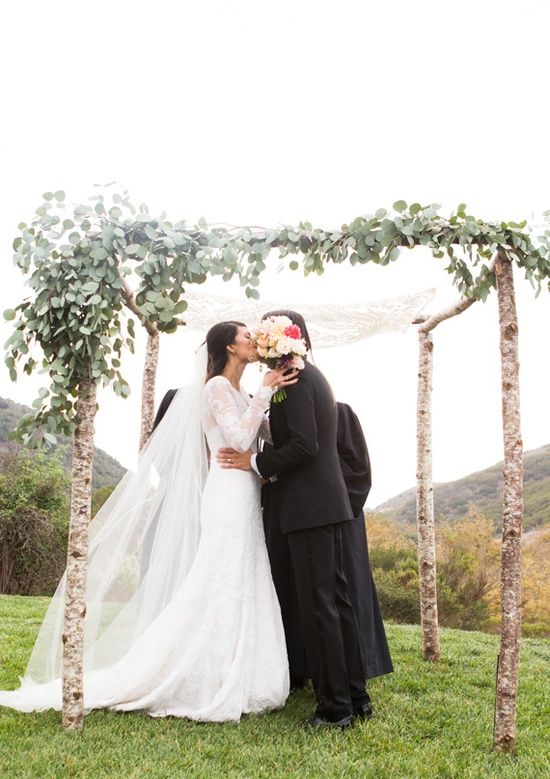 wooden chuppah accentuated with asymmetrically placed foliage