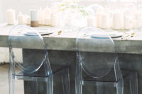23 transparent chairs and a concrete table for a minimalist tablescape