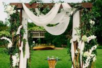 25 lush arch with white fabric and a lot of flowers and greenery