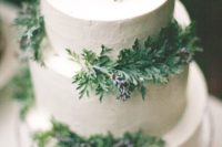 26 a three-tier white wedding cake with wintry evergreens