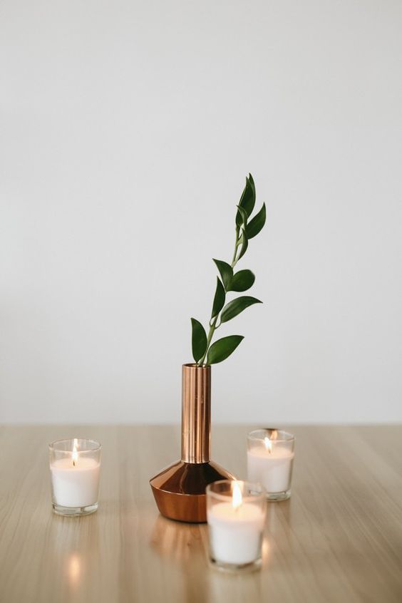 candles and a copper vase with leaves for a modern centerpiece