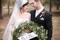 29 evergreen winter wedding wreath with a small sign