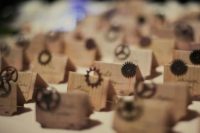 32 seating cards decorated with gears for a steampunk wedding