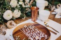 33 wooden place settings, hand lettering, lush foliage styled arrangements and a copper cup