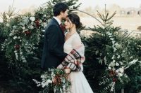 Christmas trees plus a gorgeous round wedding arch with greenery, white and burgundy blooms are amazing as a backdrop for a Christmas wedding