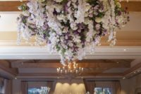 an elegant floral chandelier was embellished with lush white and lavender flowers