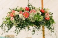 awesome flower and greenery chandelier on a hook above the tented reception