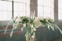 ferns and assorted white flowers suspended above tables in this warehouse venue add a touch of romance