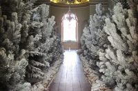 flocked Christmas trees, snowy firewood and artificial snow turn this Christmas wedding ceremony space into a real snowy forest
