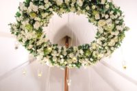large green and white floral chandelier with crystal candle holders for a tented reception