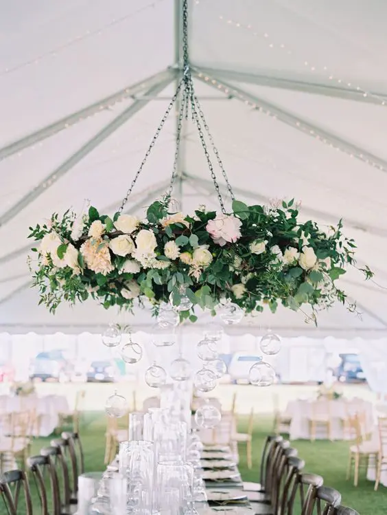 romantic white flower chandelier with greenery for a wedding reception